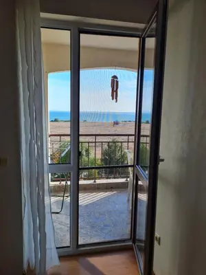 a door to a balcony with a view of the ocean at Entire apartment 4pax , sea view, pool in Ravda