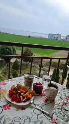 a table with a plate of food on a balcony at Entire apartment 4pax , sea view, pool in Ravda