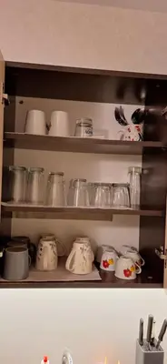 a kitchen shelf filled with pots and pans at Entire apartment 4pax , sea view, pool in Ravda