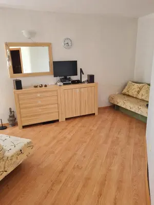 a living room with a television on a dresser with a mirror at Entire apartment 4pax , sea view, pool in Ravda