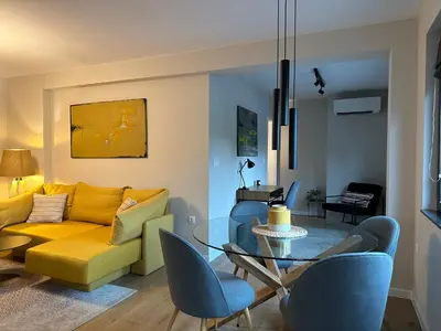 a living room with a yellow couch and a glass table at Cosy Apartment - Top Location in Burgas City