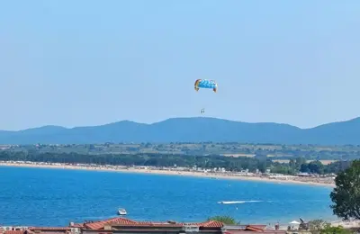 a view of a beach with a tower in the distance at Студио Море in Chernomorets