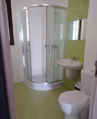 a bathroom with a shower and a toilet and a sink at Студио Море in Chernomorets