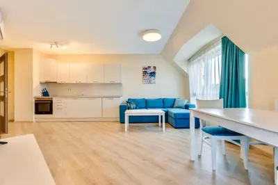 a living room with a blue couch and a table at AT apartment - Sea View in Varna City