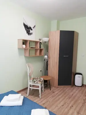 a room with a bed and a table and a cabinet at SPS Apartment in Varna City