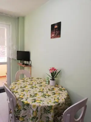 a dining room table with a flower patterned table cloth at SPS Apartment in Varna City
