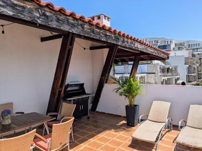 a patio with chairs and a grill on a balcony at Beachfront Apartment Sveti Vlas in Sveti Vlas