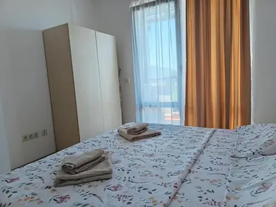 a bedroom with a bed with towels on it at Апартамент Плаж Червенка in Chernomorets