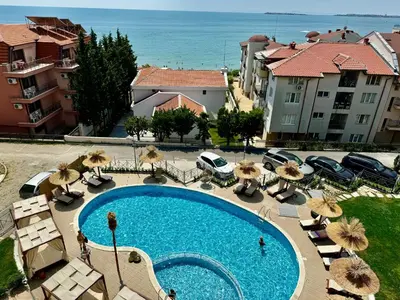 a large swimming pool with chairs and umbrellas at Апартамент СВЕТИ ВЛАС 1 in Sveti Vlas