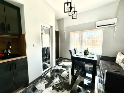 a small living room with a table and a kitchen at Апартамент СВЕТИ ВЛАС 1 in Sveti Vlas