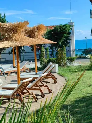 a group of lounge chairs and umbrellas on a deck at Студио СВЕТИ ВЛАС 2 in Sveti Vlas