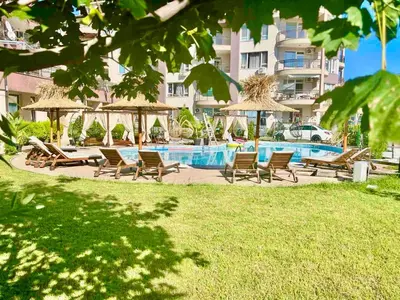 a group of chairs and umbrellas next to a swimming pool at Студио СВЕТИ ВЛАС 2 in Sveti Vlas