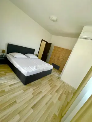 a bedroom with a bed and a wooden floor at Majestic Villas Pomorie Park in Sarafovo