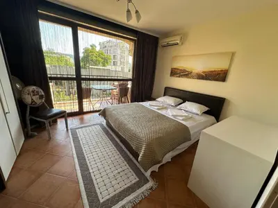 a bedroom with a bed and a view of a balcony at Kalia A5 Sunny Beach in Sunny Beach