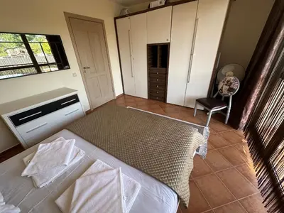 a bedroom with a bed and a chair in it at Kalia A5 Sunny Beach in Sunny Beach