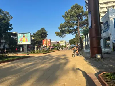 a person riding a bike down a city street at Kalia A5 Sunny Beach in Sunny Beach
