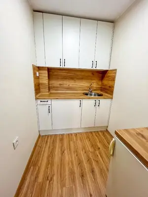 a small kitchen with white cabinets and a sink at Cosy Home in Burgas City
