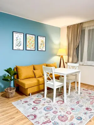 a living room with a table and a yellow couch at Cosy Home in Burgas City