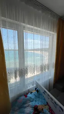 a childs room with a window and a bed with toys at Studio Kikki Sozopol in Sozopol