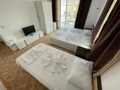 a hotel room with two beds and a couch at Apartments Lozenets in Lozenets