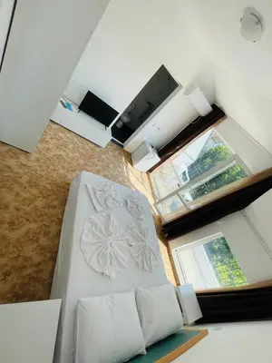 a white bed in a room with windows at Apartments Lozenets in Lozenets