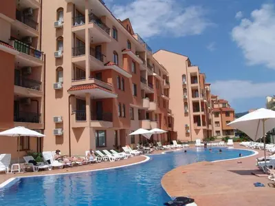a swimming pool in a hotel with chairs and umbrellas at 2 Bedroom Apartment at Kasandra in Sunny Beach