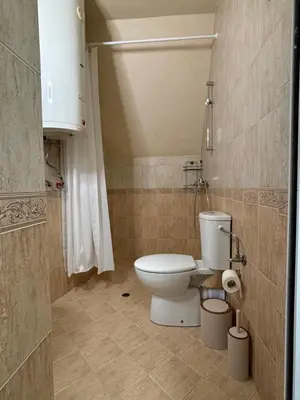 a bathroom with a white toilet in a room at Студио за гости При Нана in Burgas City