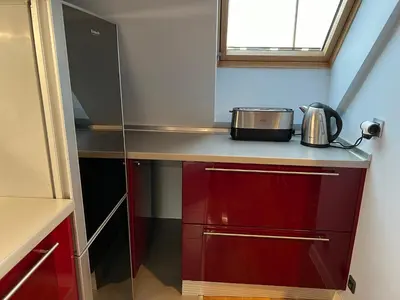a small kitchen with red cabinets and a toaster at Roman Thermae Heritage Penthouse with Garage in Varna City