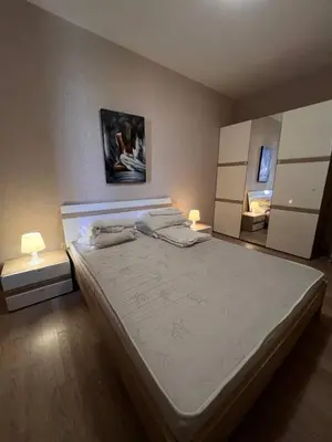 a bedroom with a large bed with two lamps on it at Комплекс Амара А4 in Sunny Beach