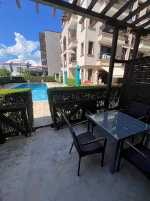 a patio with a table and chairs next to a building at Комплекс Амара А4 in Sunny Beach