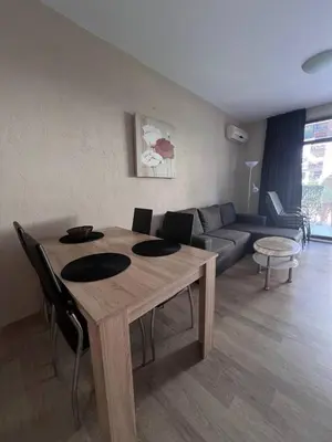 a living room with a wooden table and a couch at Комплекс Амара А4 in Sunny Beach