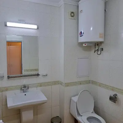 a bathroom with a sink and a toilet and a mirror at Студио Дарис in Nesebar