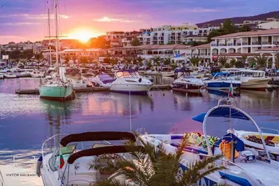 a group of boats docked in a marina at sunset at HARMONY SUITES Grand Resort PREMIUM Ferienwohnung in Sunny Beach