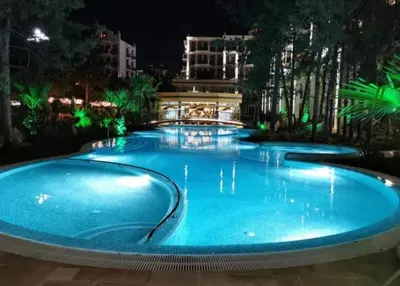 a large blue swimming pool at night at HARMONY SUITES Grand Resort PREMIUM Ferienwohnung in Sunny Beach