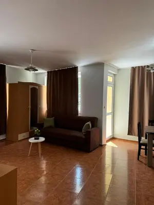 a living room with a couch and a table at Апартамент Александър in Sunny Beach