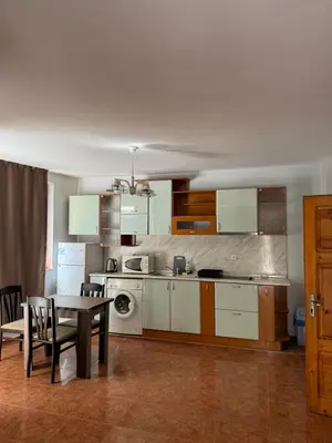 a kitchen with a table and a dining room at Апартамент Александър in Sunny Beach