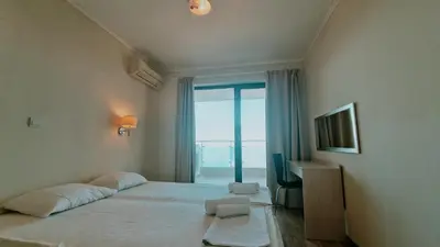 a bedroom with a large bed with a large window at Апартаменти Бяла Бийч - Apartments Byala Beach in Byala