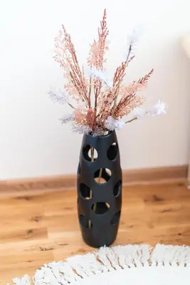 a black vase with a plant in it at Boris Garden Comfort Suite in Burgas City