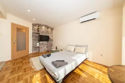 a bedroom with a large bed and a table at Boris Garden Comfort Suite in Burgas City