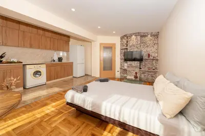 a large bedroom with a large bed and a kitchen at Boris Garden Comfort Suite in Burgas City