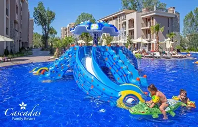 two children playing in a water slide at a resort at Cascadas pool view luxury apartment Sunny beach in Sunny Beach