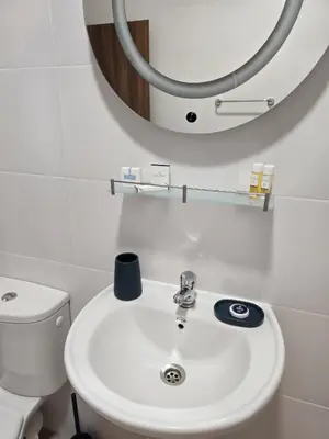 a bathroom with a white sink and a mirror at Апартамент 