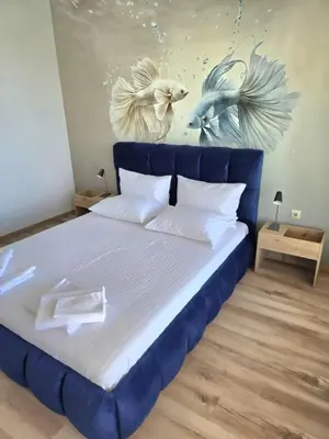 a bedroom with a blue bed with two birds on the wall at Апартамент 