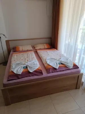 two beds with bow ties on them in a bedroom at MIDIA Family Resort - studio s výhledem na moře in Aheloy
