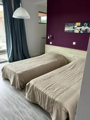 two beds sitting next to each other in a bedroom at Sunny house in Pismenovo