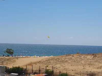 a beach with people on the sand and the ocean at Sea Apartament Kristal Beach,Nessebar in Nesebar