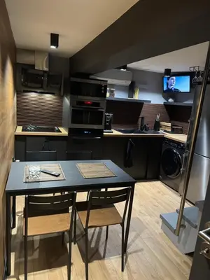 a small kitchen with a table and a kitchen with a tv at Casa Raffaelo in Burgas City