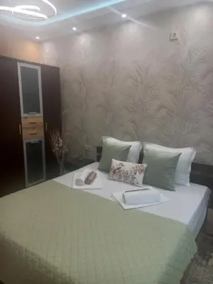 a bedroom with a bed with two slippers on it at Guest House Dani in Pomorie