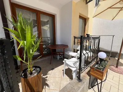 a living room with a plant and a table and chairs at Apartament Studio Bułgaria Garden Of Eden in Sveti Vlas