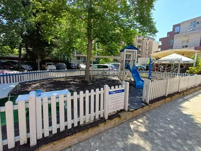 a white picket fence around a tree in a playground at Admiral Plaza 35 -studio-Sunny Beach in Sunny Beach